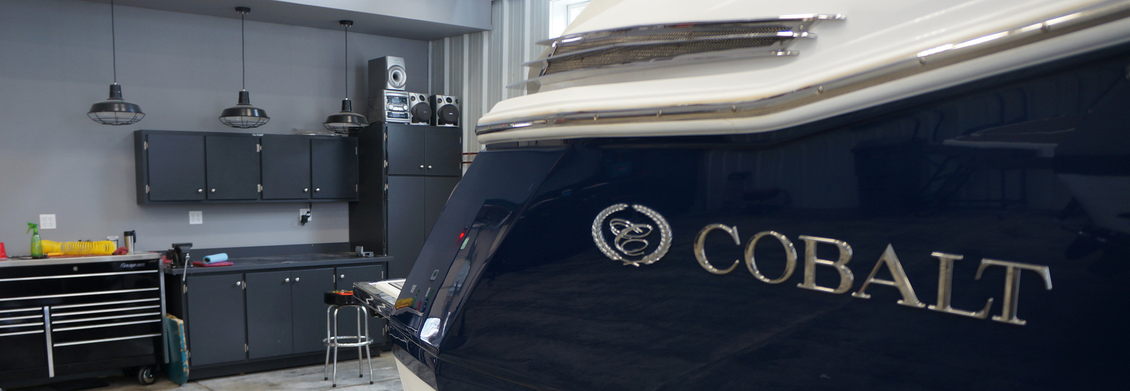 A cobalt boat sits front and center as it rests in a shop waiting to be serviced.